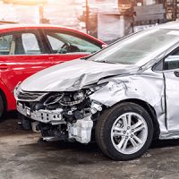 Many wrecked car after traffic accident crash at restore service maintenance station garage indoor. Insurance salvage vehicle auction wholesale storage. Auto body wreck damage work workshop center